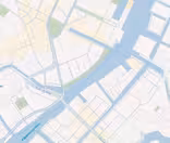 A digital map showing a river running through a city, with various bridges and streets labeled in Danish. The area includes buildings, parks, and waterways, illustrating a part of a city with detailed planning lines.